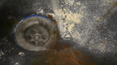 Çok eski, paslı, pejmürde bir banyo.