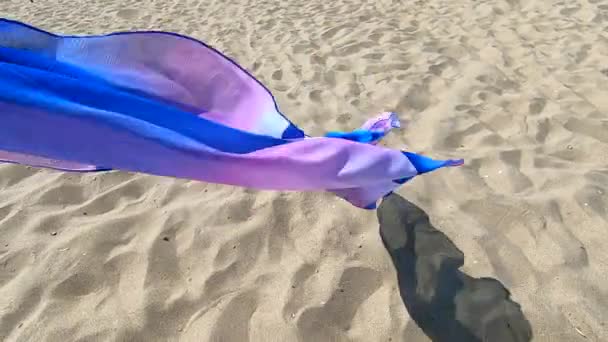 Transparent shawl in wind over sand of sea shore with dark shadow — Stock Video