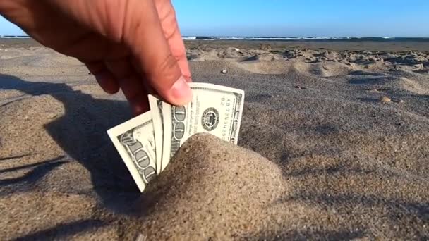 Ein Mädchen holt aus dem Sand Geldscheine von dreihundert — Stockvideo