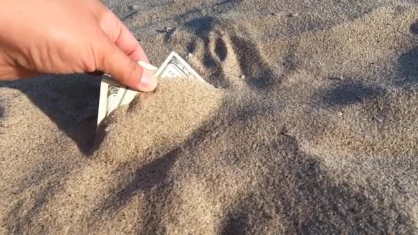 Een meisje haalt uit het zand biljetten van driehonderd — Stockvideo