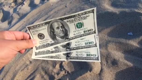 Dívka držící peníze účet 300 dolarů na pozadí přes písek — Stock video