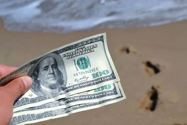 Meisje met geld rekening van 300 dollar op de achtergrond van de zee oceaan — Stockfoto
