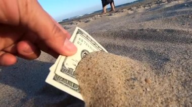Bir kız üç yüz doların kumdan paralarını alır.