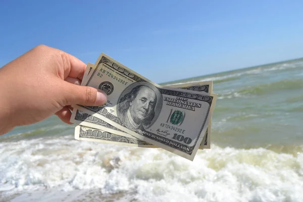 Meisje met een biljet van 300 dollar op de achtergrond van de zee golven — Stockfoto