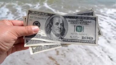Elinde 300 dolarlık deniz arkası faturası tutan kız.