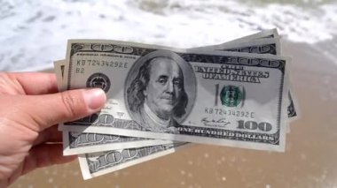 Elinde 300 dolarlık deniz arkası faturası tutan kız.