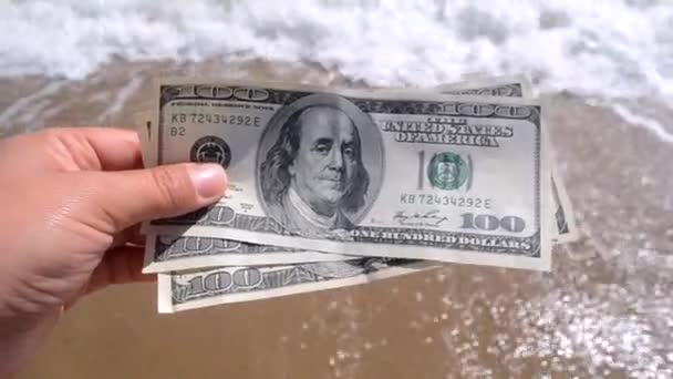 Girl holding money bill of 300 dollars on background of sea oceans — ストック動画