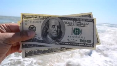 Elinde 300 dolarlık deniz arkası faturası tutan kız.