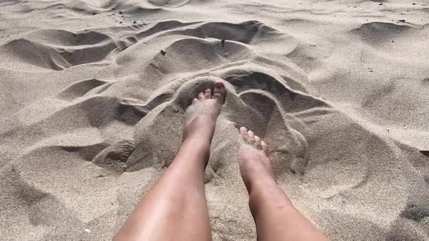 Zwei Beine eines kaukasischen Mädchens weiblich genießen weißen Sand auf einem sandigen Schnabel — Stockvideo