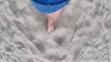 Okyanus adasının kıyısında kumlu sahilde yürüyen bir kız..