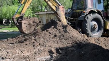 Traktör toprağı kazıyor. Kepçeler yere yakın çekim yapıyor..