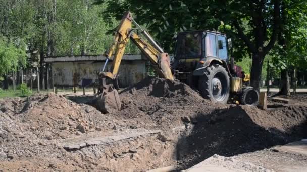 Backhoe se hromadí na zemi zblízka. — Stock video