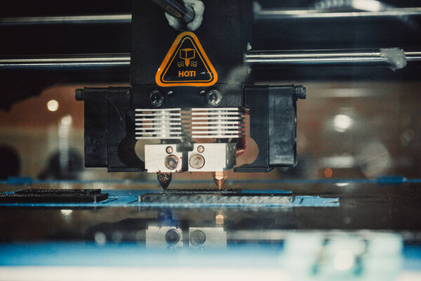 3d printer printing black flat shapes close-up
