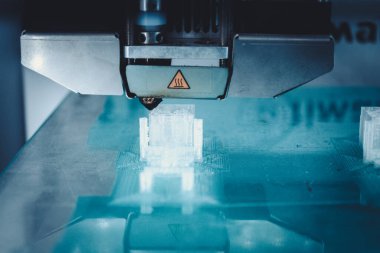 3D yazıcı çalışıyor ve sıcak erimiş plastikten bir nesne oluşturuyor