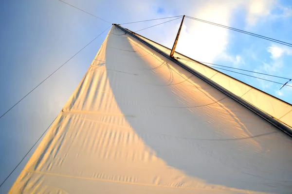 Белый парус на закате, восход солнца на лодке с голубым небом — стоковое фото