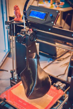 3D yazıcı siyah vazo gibi yakın plan bir model yazdırıyor.
