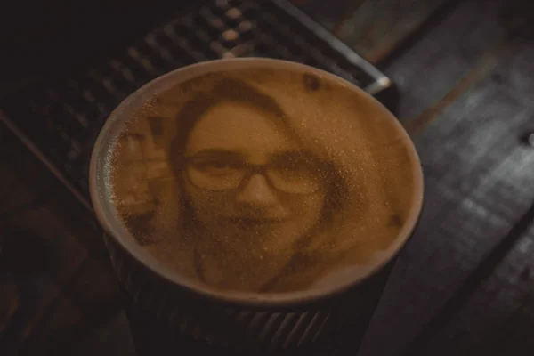 Drawing of a womans face on a foam coffee latte in a glass created by coffe — Stock Photo, Image