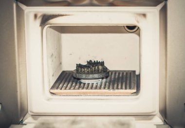 Object printed on metal 3d printer in the kiln for sintering after heat treatment synterization close-up.