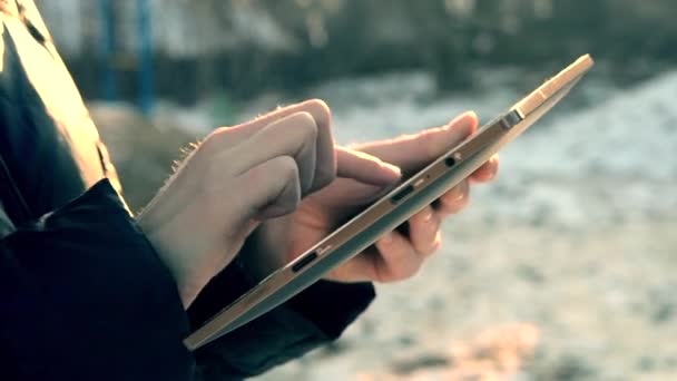 Girl flips through photos on a tablet close-up — Stockvideo