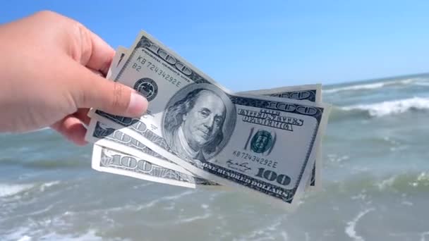 Man holds three hundred dollar banknotes in his hands on a background — Stock Video