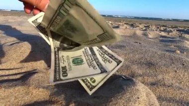 Girl holding money bill of 300 dollars on background of blue sky