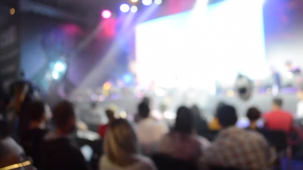 Fundo borrado grande tela palco muitas pessoas holofotes multicoloridos — Vídeo de Stock