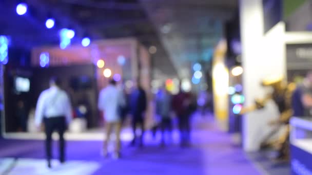 Blurred Background. People are standing behind counter in of purple hall. — 비디오