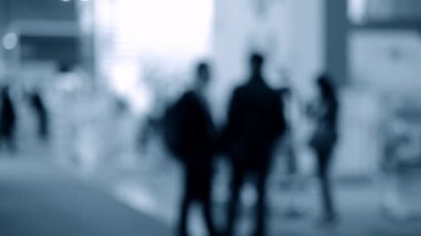 Bulanık arka plan çalışanları AVM 'de yürüyüş yapıyorlar.