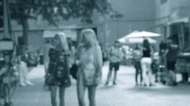 İnsanlar güneşli bir günde şehirde bir festivalde sokakta yürürler..