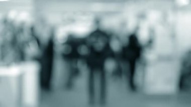 Bulanık arka plan çalışanları AVM 'de yürüyüş yapıyorlar.