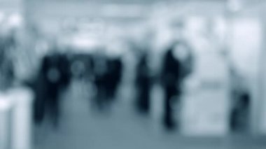 Bulanık arka plan çalışanları AVM 'de yürüyüş yapıyorlar.