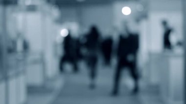 Bulanık arka plan çalışanları AVM 'de yürüyüş yapıyorlar.