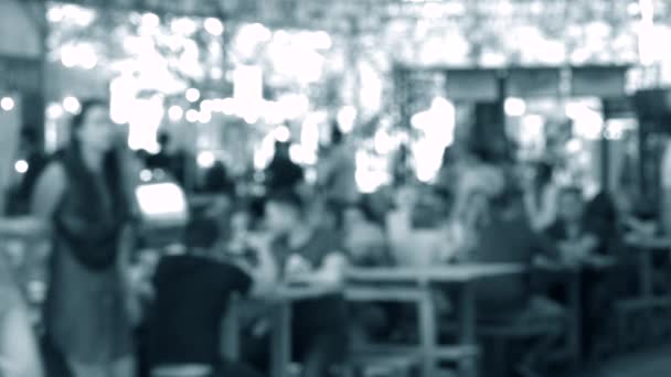 Many people sit at the tables and eat at the festival. Blurred background — Stock Video
