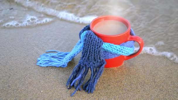 Rote Tasse mit heißem Kaffee und Dampftee, gebunden mit blauem Strickschal — Stockvideo