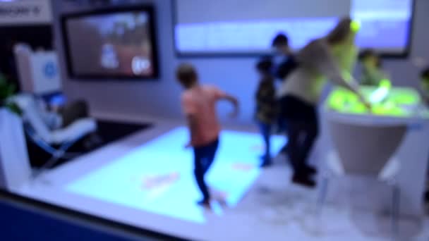 Wazige achtergrond. Twee kinderen spelen een spel dat de projector projecteert — Stockvideo