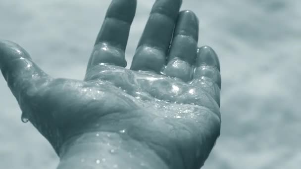 Gotas de nieve derretida caen en la palma de la mano con el resplandor del sol — Vídeos de Stock