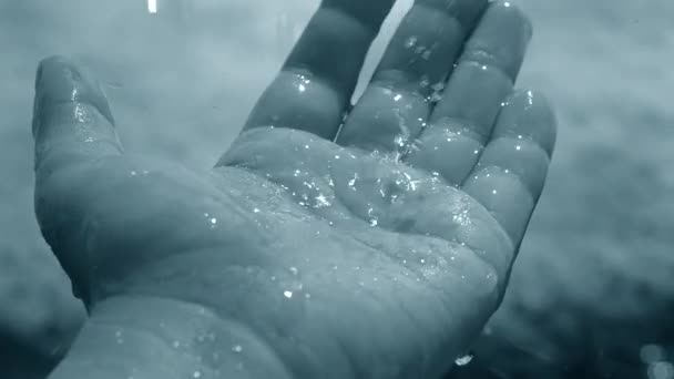 Des gouttes de neige fondante tombent sur la paume avec l'éclat du soleil — Video