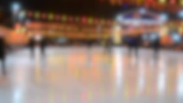 As pessoas andam em uma pista de gelo com luminosa lâmpada de guirlanda amarelo-vermelho brilhante — Vídeo de Stock