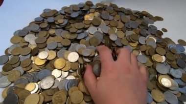 Kız eline bir avuç bozuk para alıp masanın üstüne fırlatıyor.