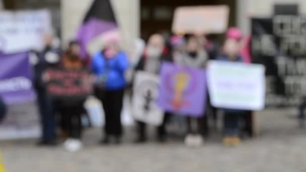 Homályos háttér. Feminista nők állnak a tér közepén, és rally. — Stock videók