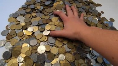 Kız eline bir avuç bozuk para alıp masanın üstüne fırlatıyor.