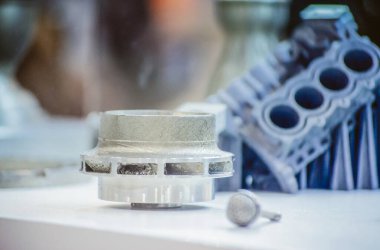 Metal 3D yazıcıya yazdırılmış nesneyi tutan adam.