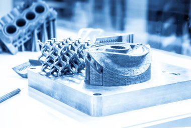 Metal 3D yazıcıya yazdırılmış nesneyi tutan adam.