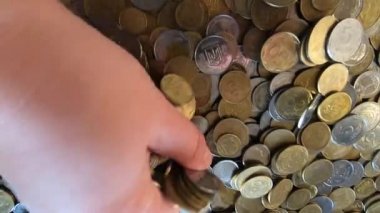 Kız eline bir avuç bozuk para alıp masanın üstüne fırlatıyor.