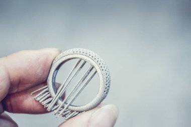 Adam metal 3D yazıcıya basılı nesne tutuyor. Nesne lazer sindirim makinesine basılmış. Metal tozundan modern 3D yazıcı baskısı. İlerici katkı maddesi DMLS, SLM, SLS 3D yazdırma teknolojisi