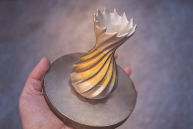 Adam metal 3D yazıcıya basılı nesne tutuyor. Nesne lazer sindirim makinesine basılmış. Metal tozundan modern 3D yazıcı baskısı. İlerici katkı maddesi DMLS, SLM, SLS 3D yazdırma teknolojisi