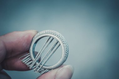 Adam metal 3D yazıcıya basılı nesne tutuyor. Nesne lazer sindirim makinesine basılmış. Metal tozundan modern 3D yazıcı baskısı. İlerici katkı maddesi DMLS, SLM, SLS 3D yazdırma teknolojisi