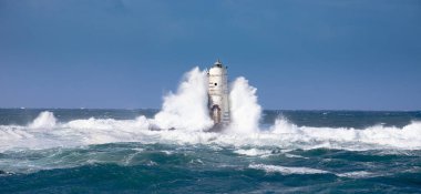 Mangiabarche deniz feneri mistral bir rüzgar fırtınasının dalgalarıyla sarılı. Deniz feneri, adını aldığı kayanın üzerine inşa edilmiş ve Sant 'Antioco Adası' nın kuzeybatı kıyısından kısa bir mesafede yer almaktadır.