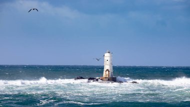 Mangiabarche deniz feneri mistral bir rüzgar fırtınasının dalgalarıyla sarılı. Deniz feneri, adını aldığı kayanın üzerine inşa edilmiş ve Sant 'Antioco Adası' nın kuzeybatı kıyısından kısa bir mesafede yer almaktadır.