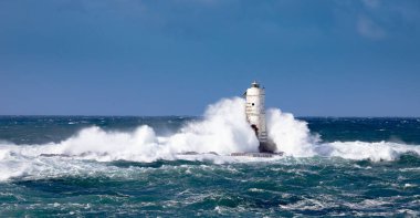 Mangiabarche deniz feneri mistral bir rüzgar fırtınasının dalgalarıyla sarılı. Deniz feneri, adını aldığı kayanın üzerine inşa edilmiş ve Sant 'Antioco Adası' nın kuzeybatı kıyısından kısa bir mesafede yer almaktadır.